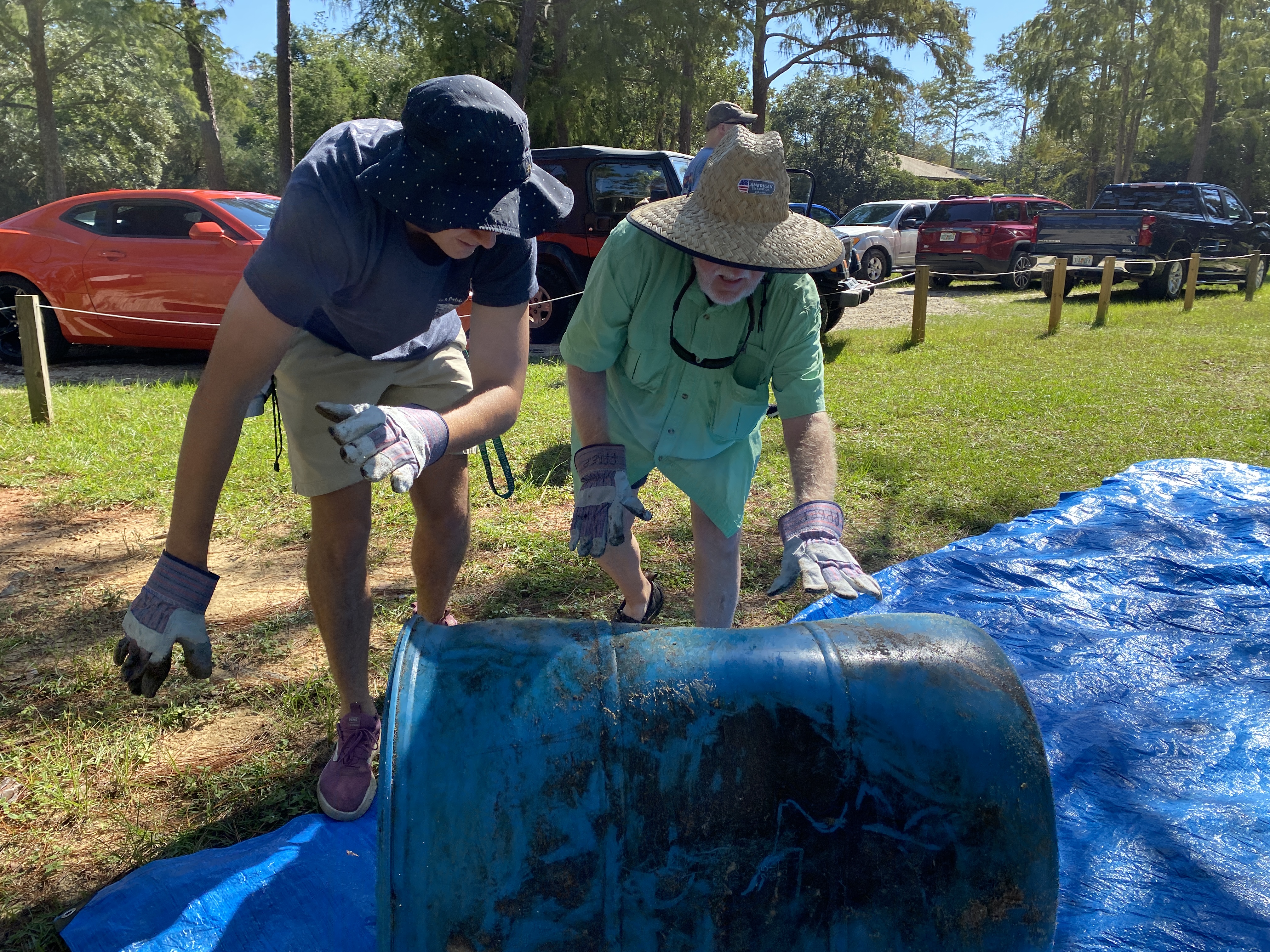 Volunteers rolling a drum