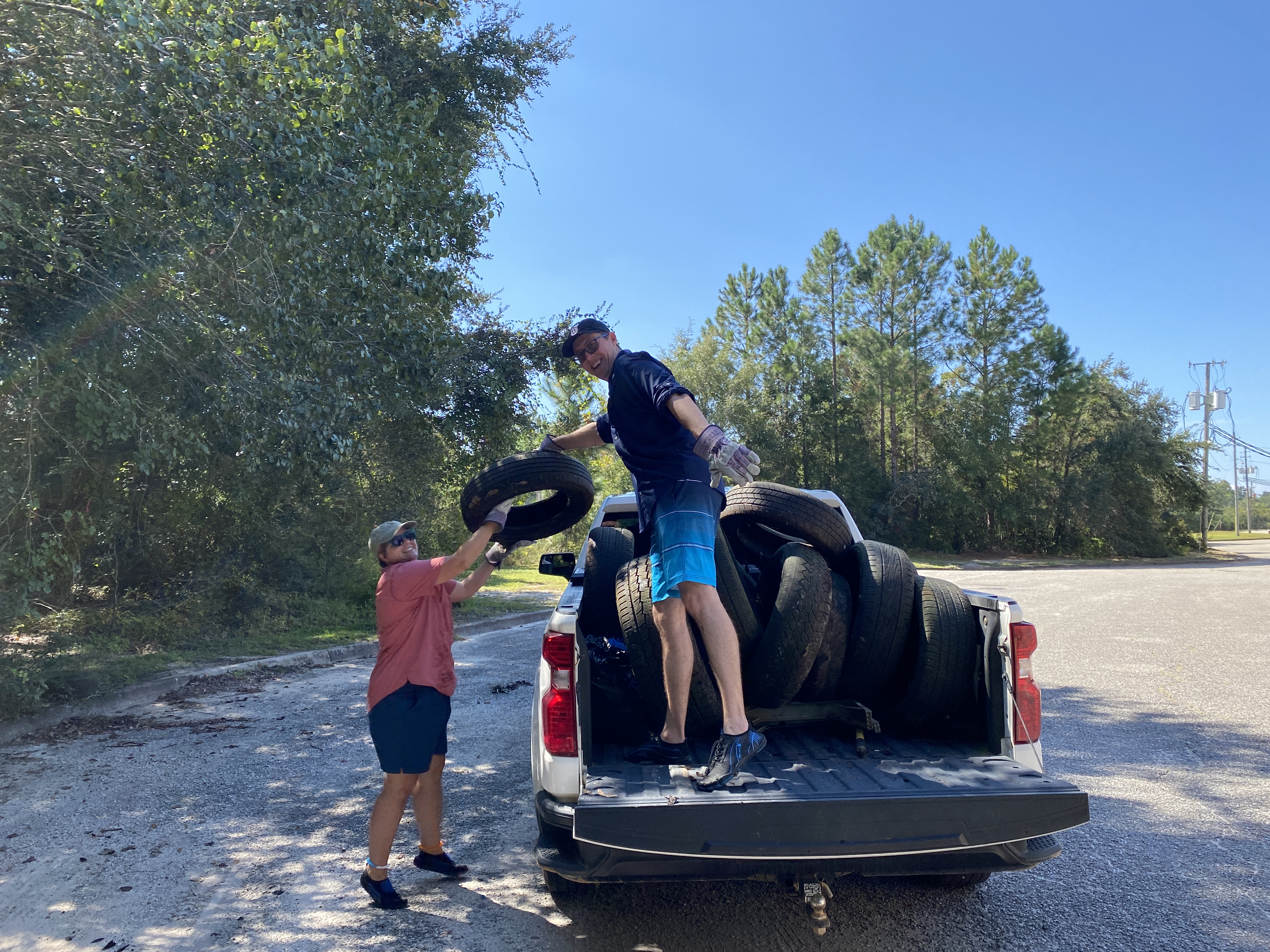 Volunteers loading a truck with tires