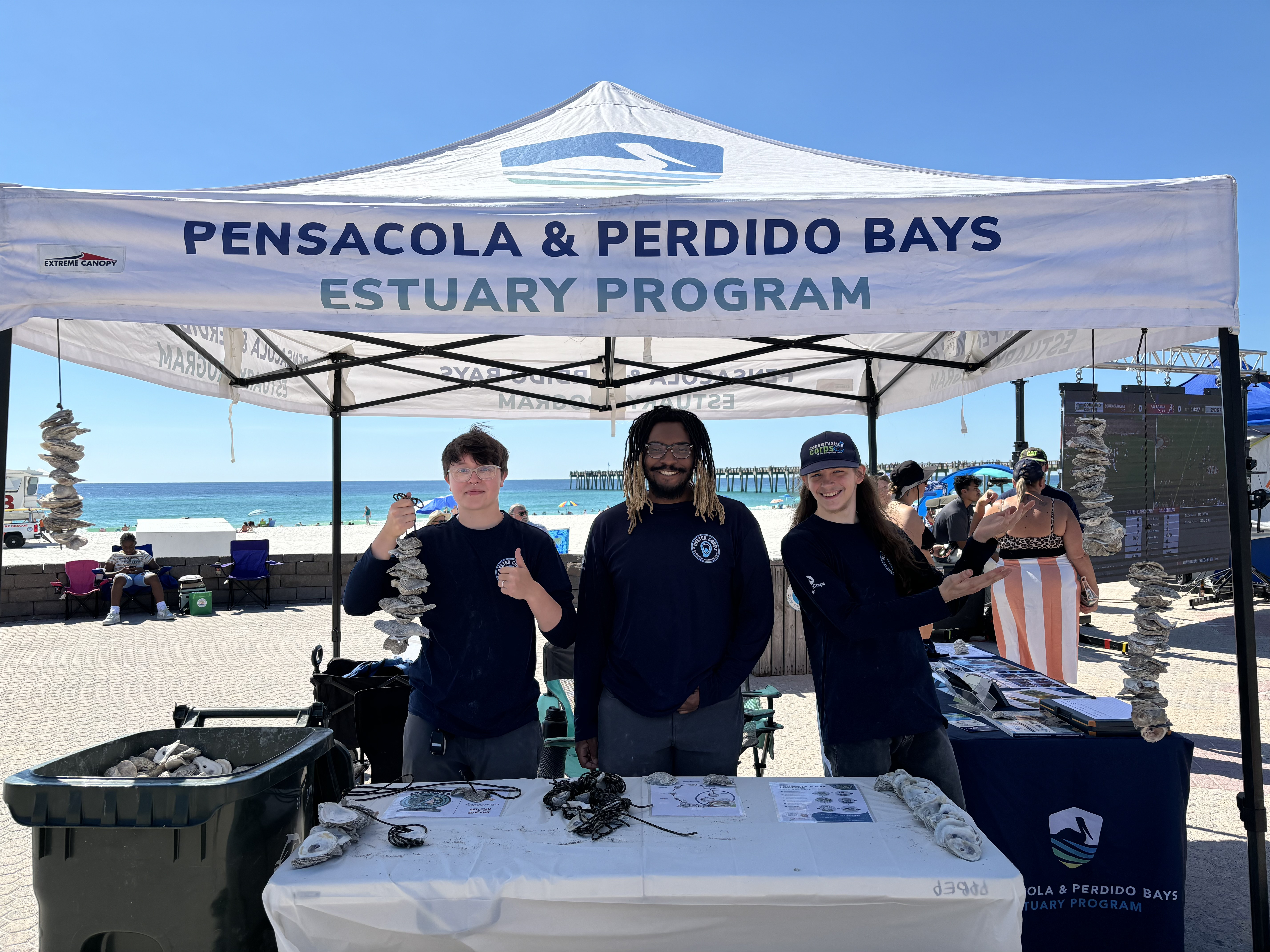 Three Oyster Corps members at booth to build vertical oyster gardens