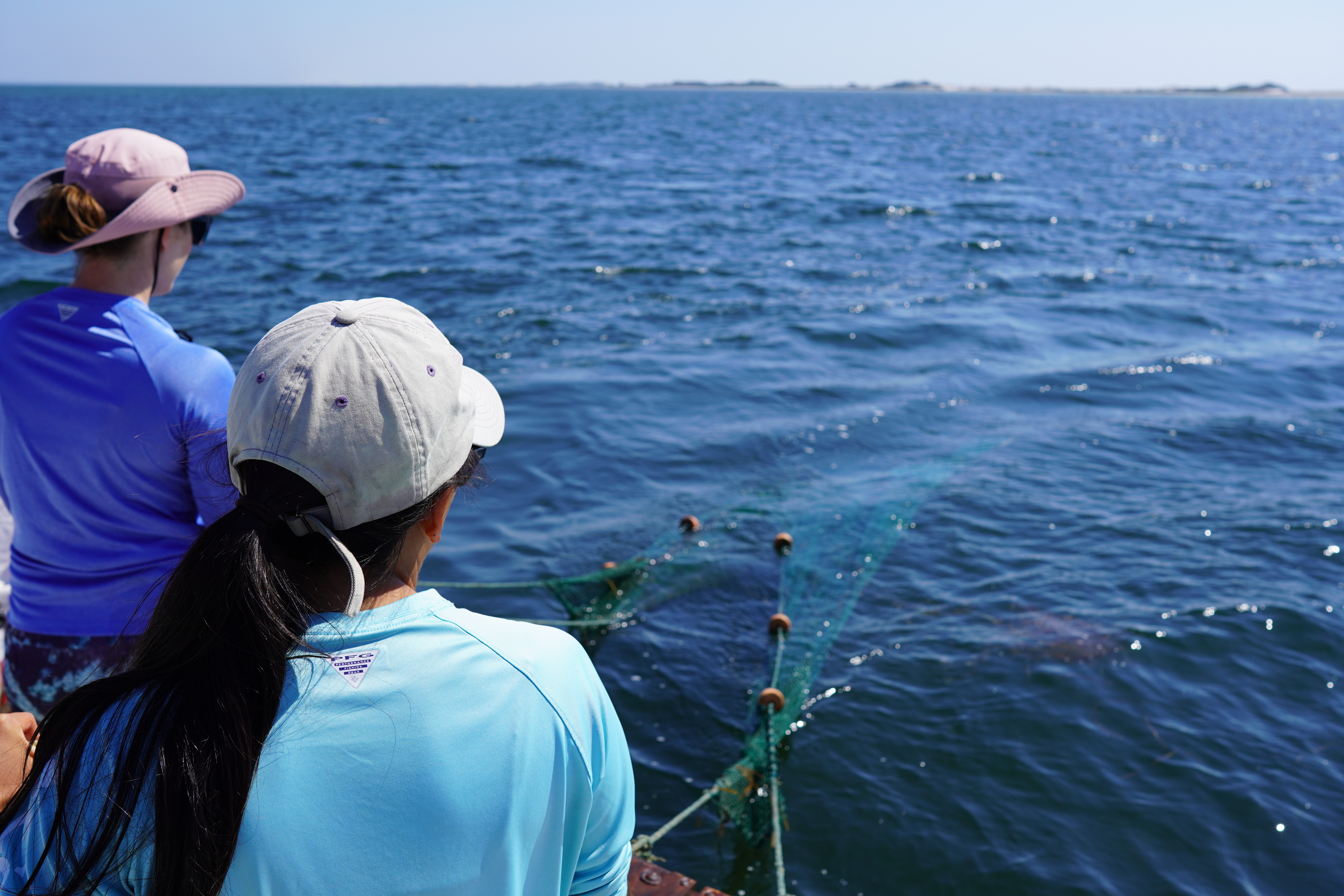 Two researchers on boat pulling trawl net