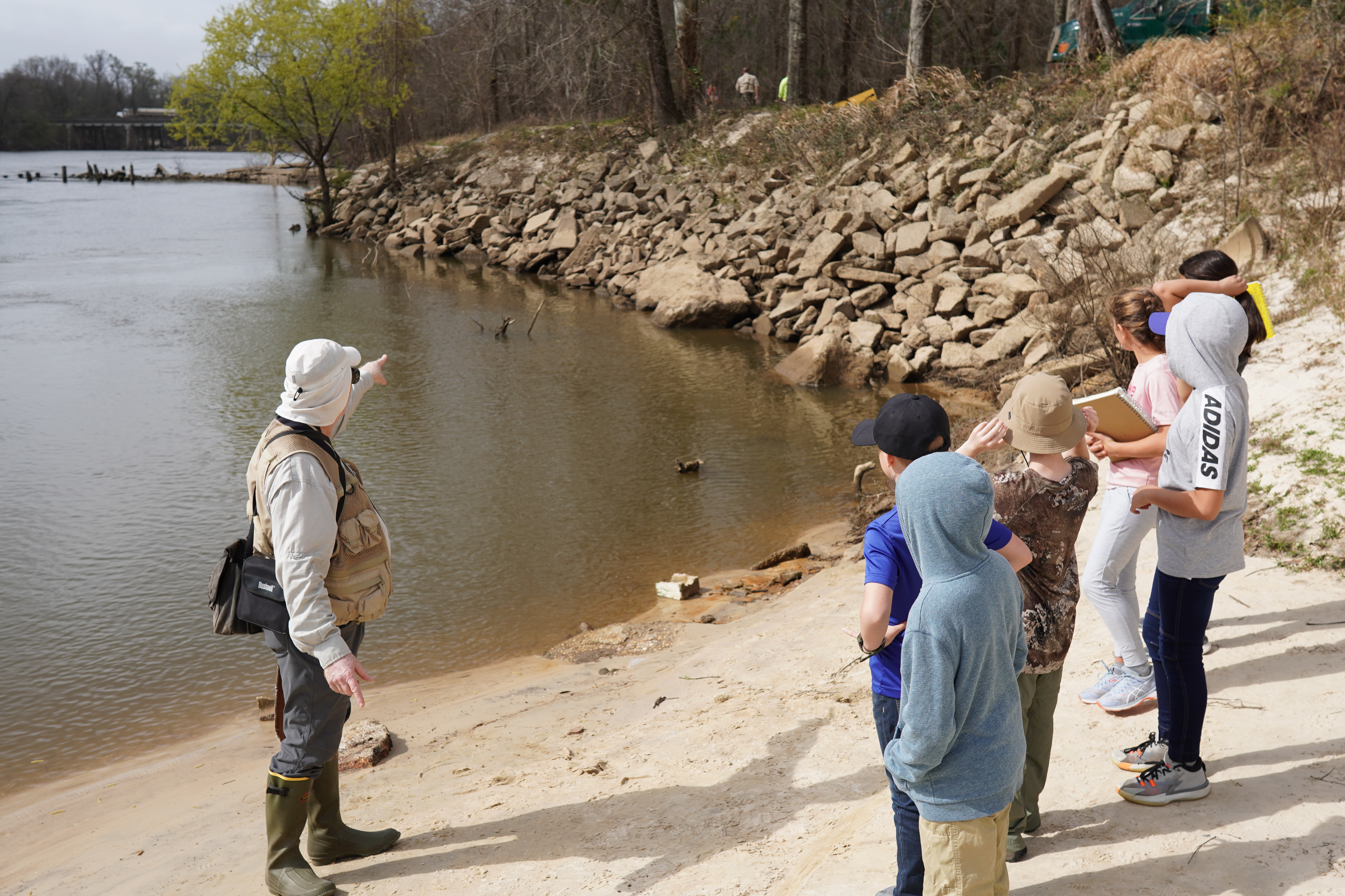 Guide teaching students near waters edge