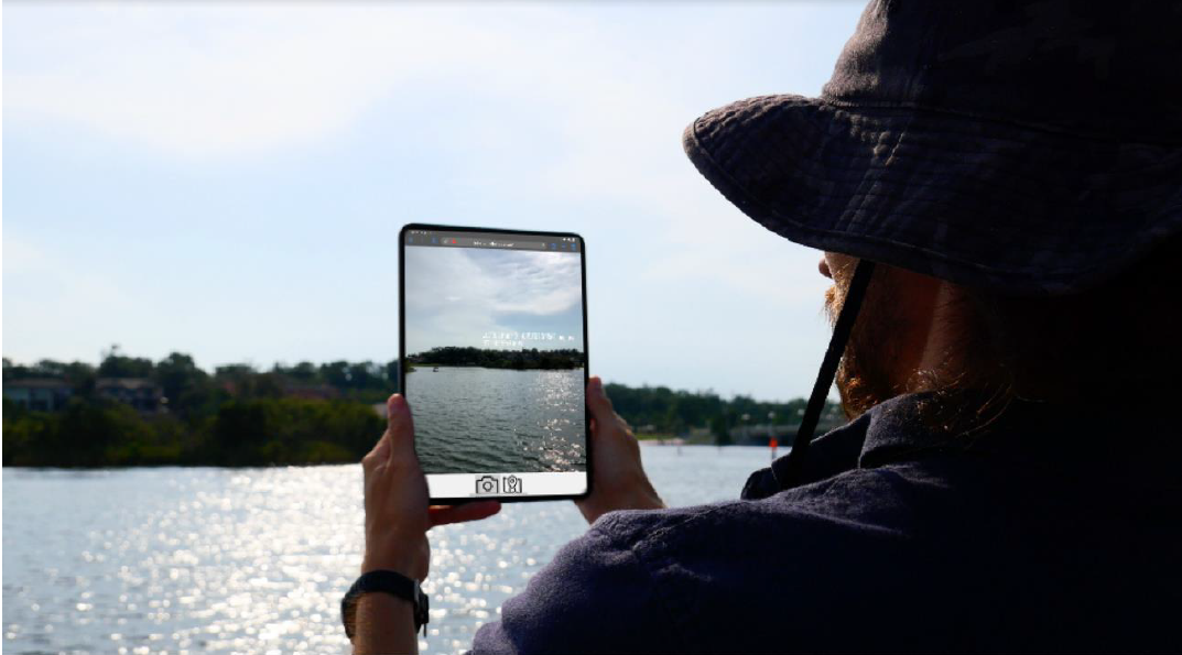 Tablet screen being held in front of water