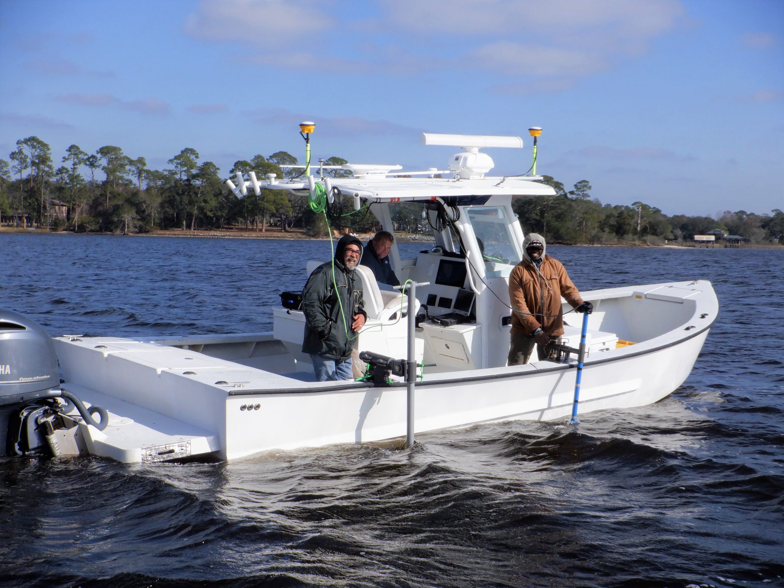 Three researchers on boat with side scan sonar 