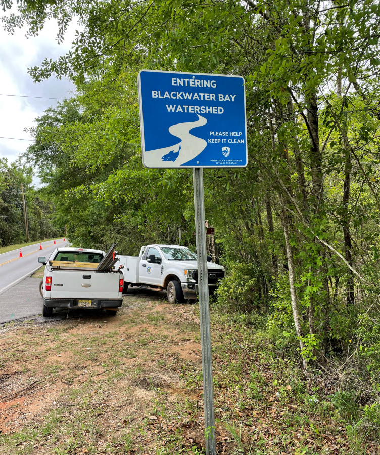 Signs reading "Entering Blackwater Bay Watershed" next to road