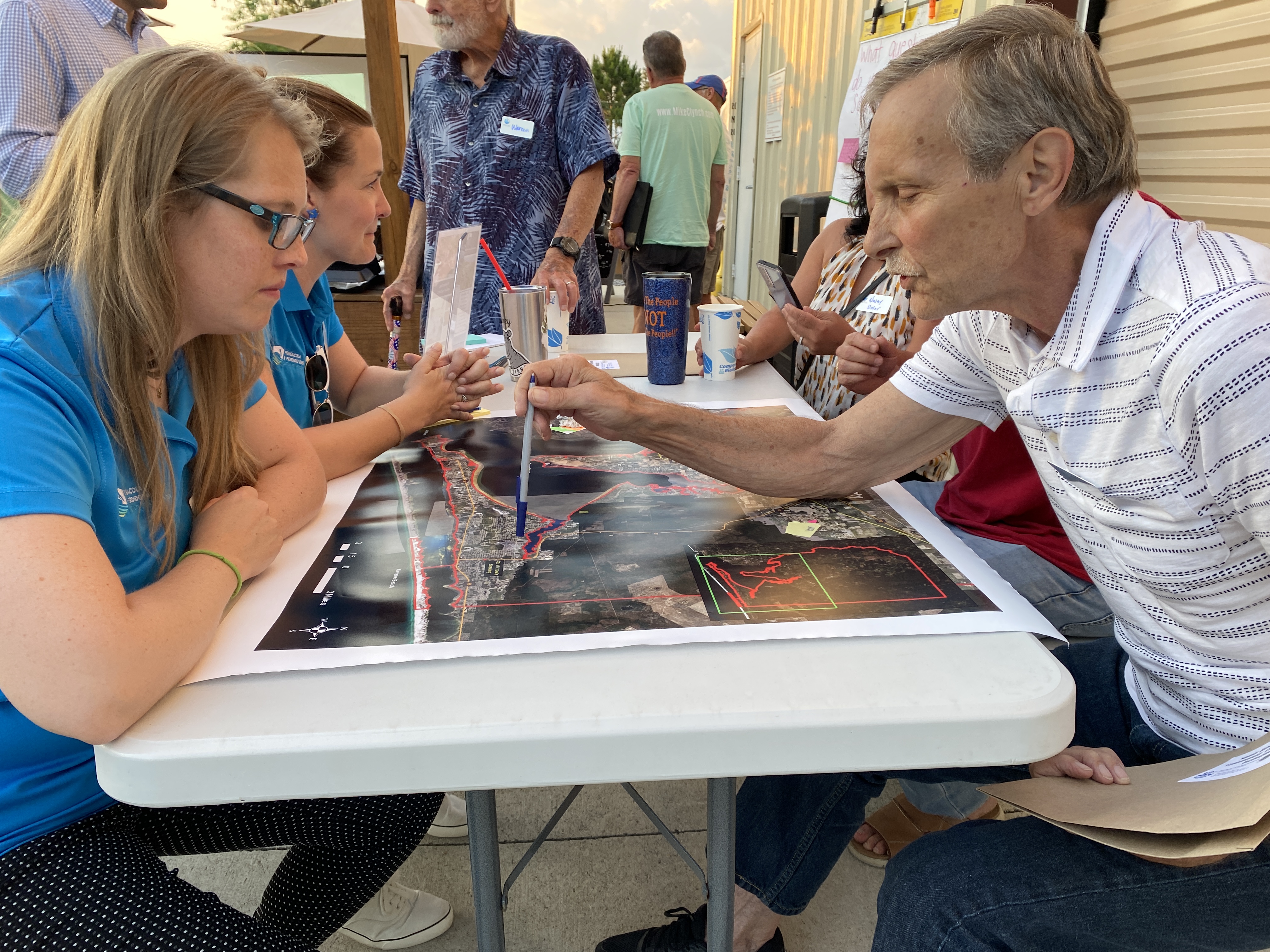 Community members sitting around a table with maps