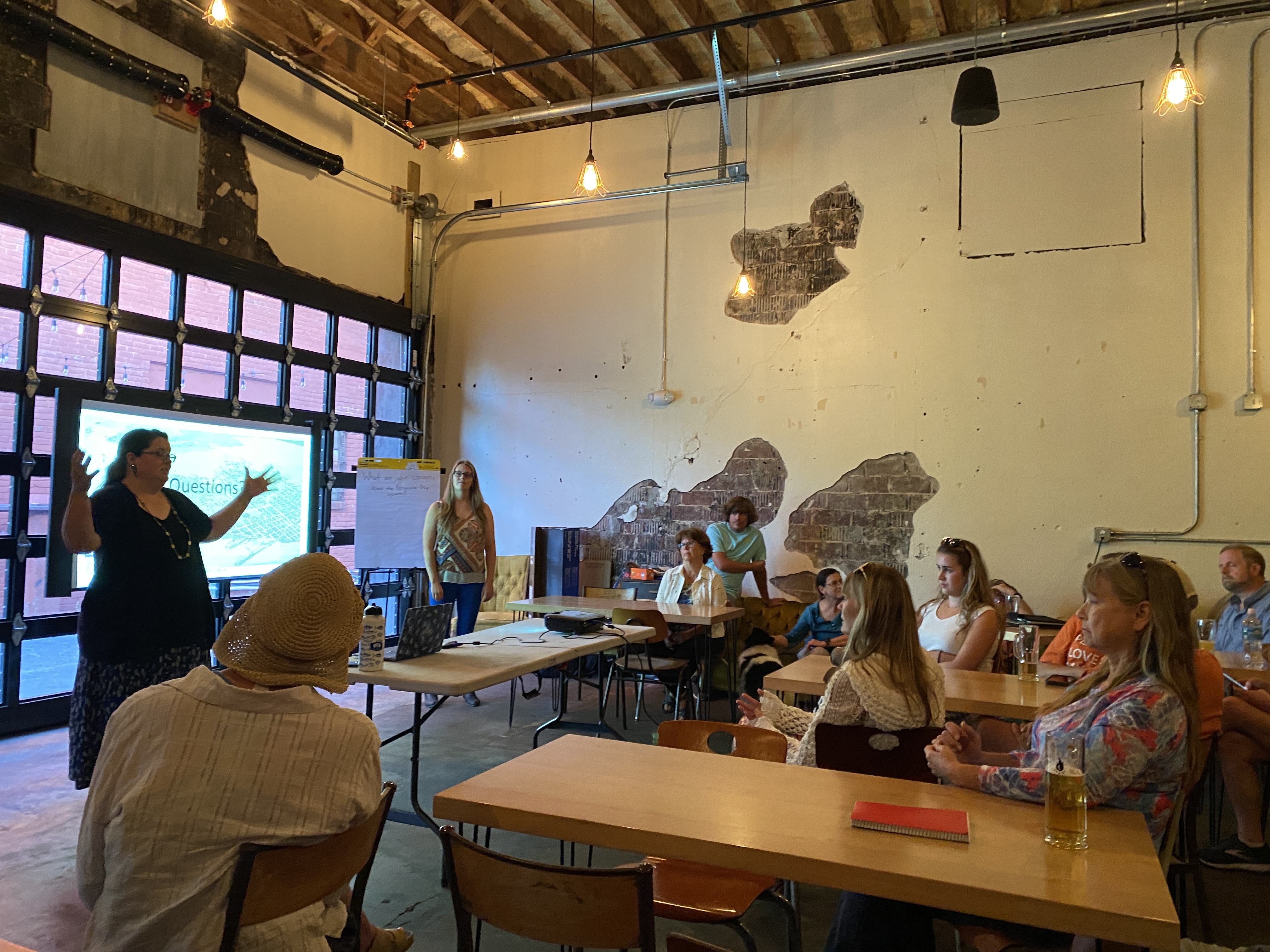 Presenter speaking to group at brewery