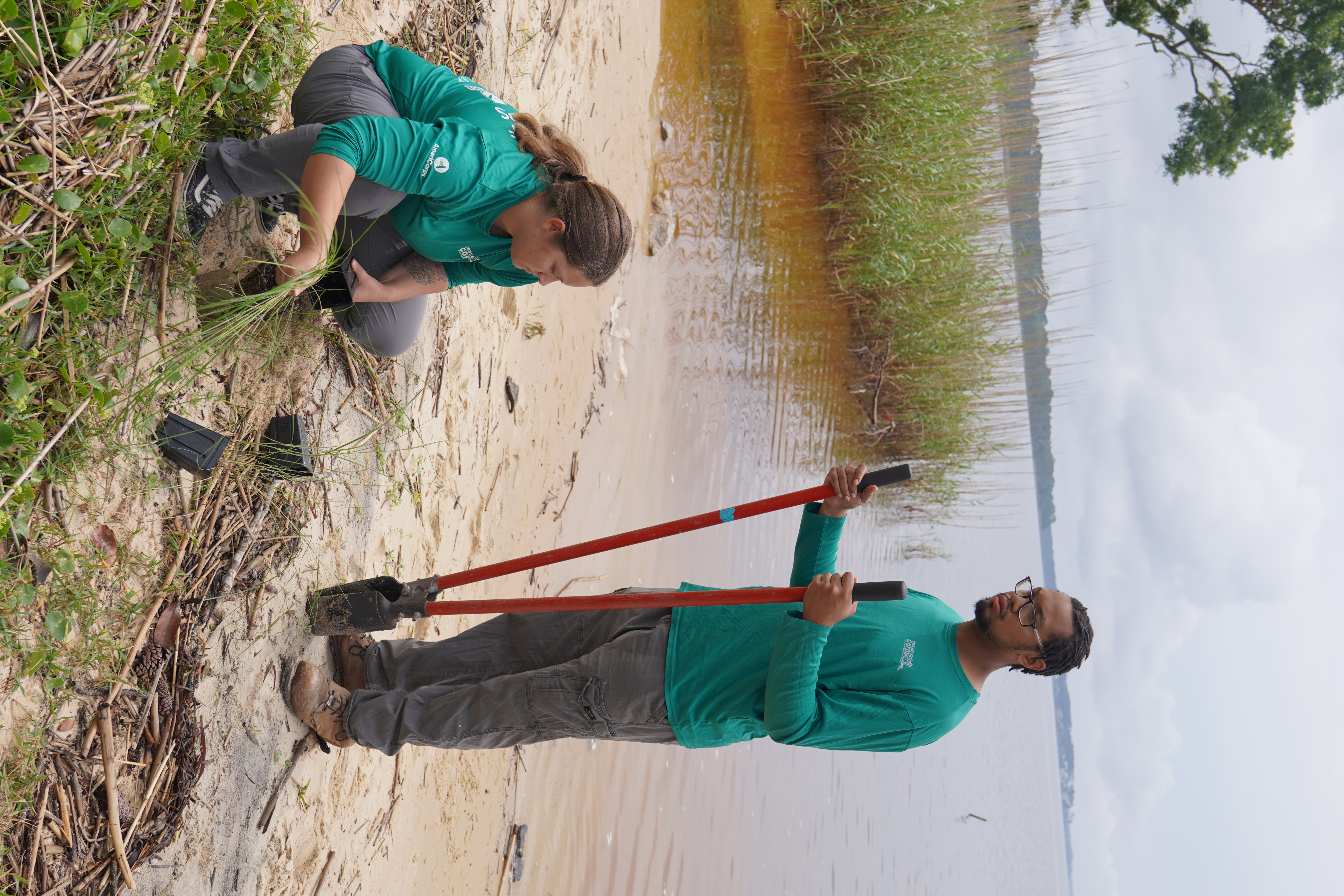 Two Oyster Corps members with shovel and grass
